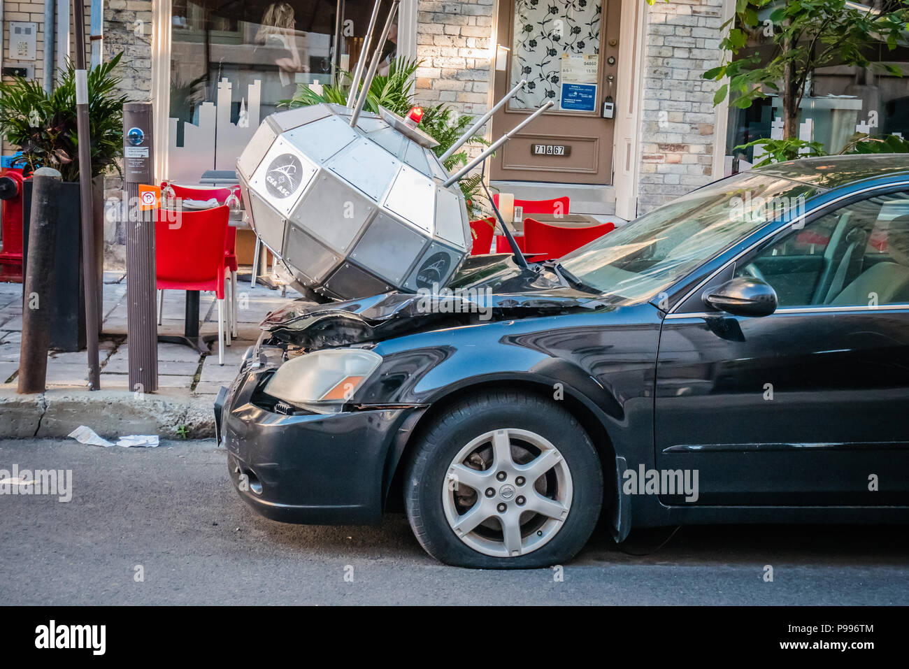 Un objet argenté endommagé l'avant d'une voiture noire Banque D'Images