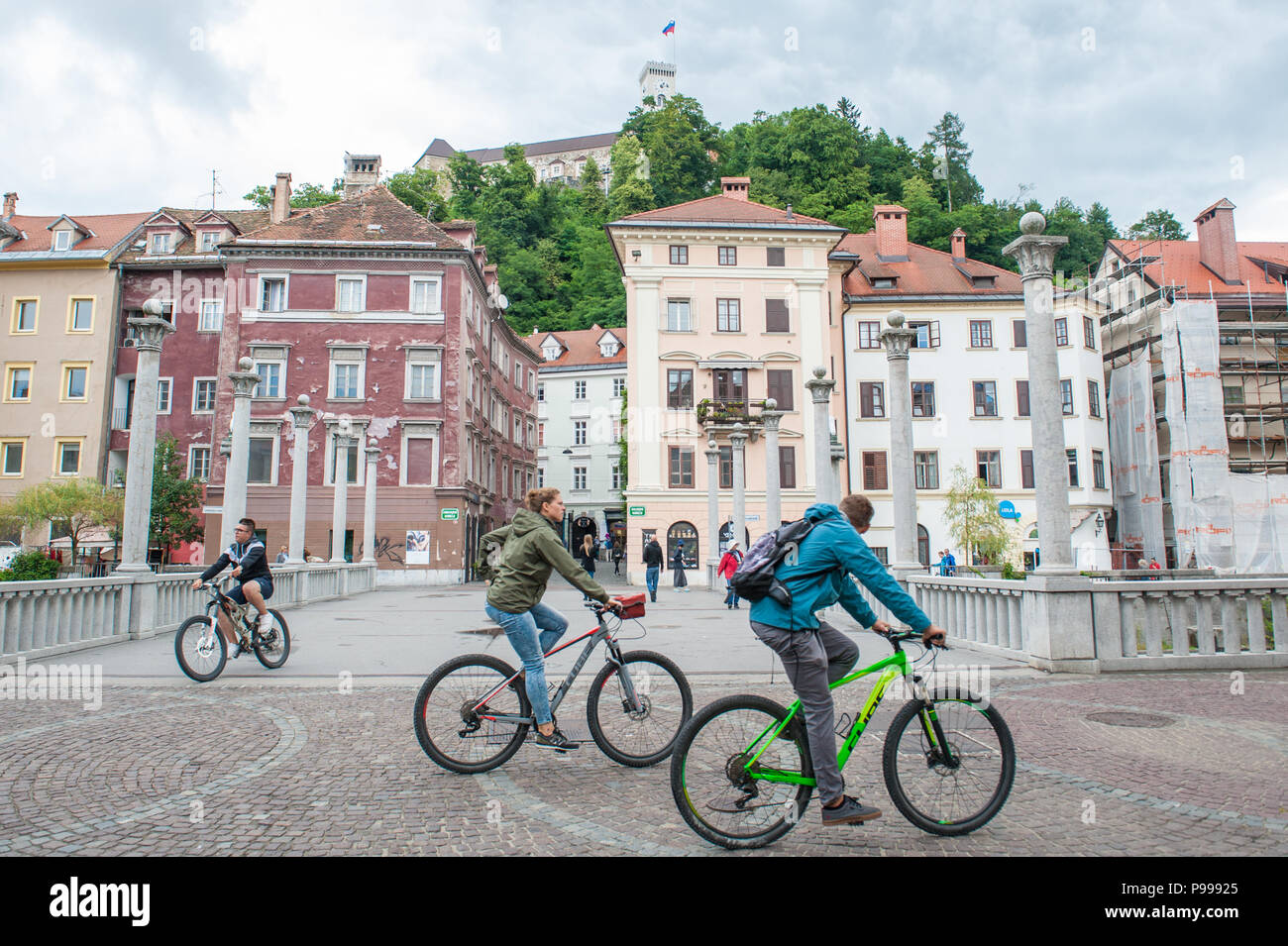 Les cyclistes passent par le cordonnier pont sur la rivière Ljubljanica dans la ville de Ljubljana, Slovénie. Banque D'Images