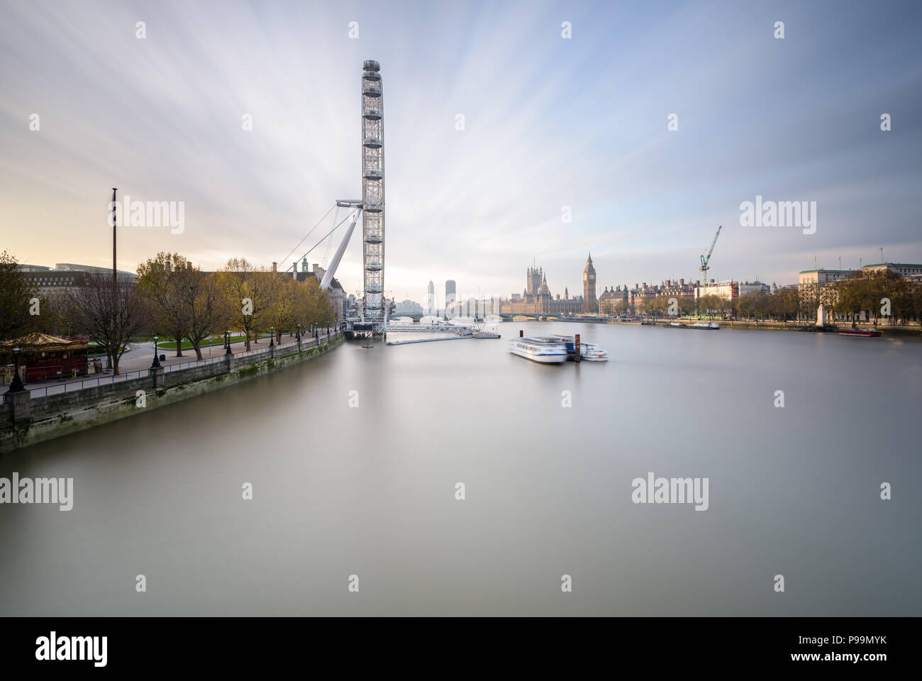 L'exposition longue vue paysage de Hungerford Bridge, Londres, vers le Coca-Cola London Eye, Westminster Bridge, Big Ben et les chambres du Parlement Banque D'Images