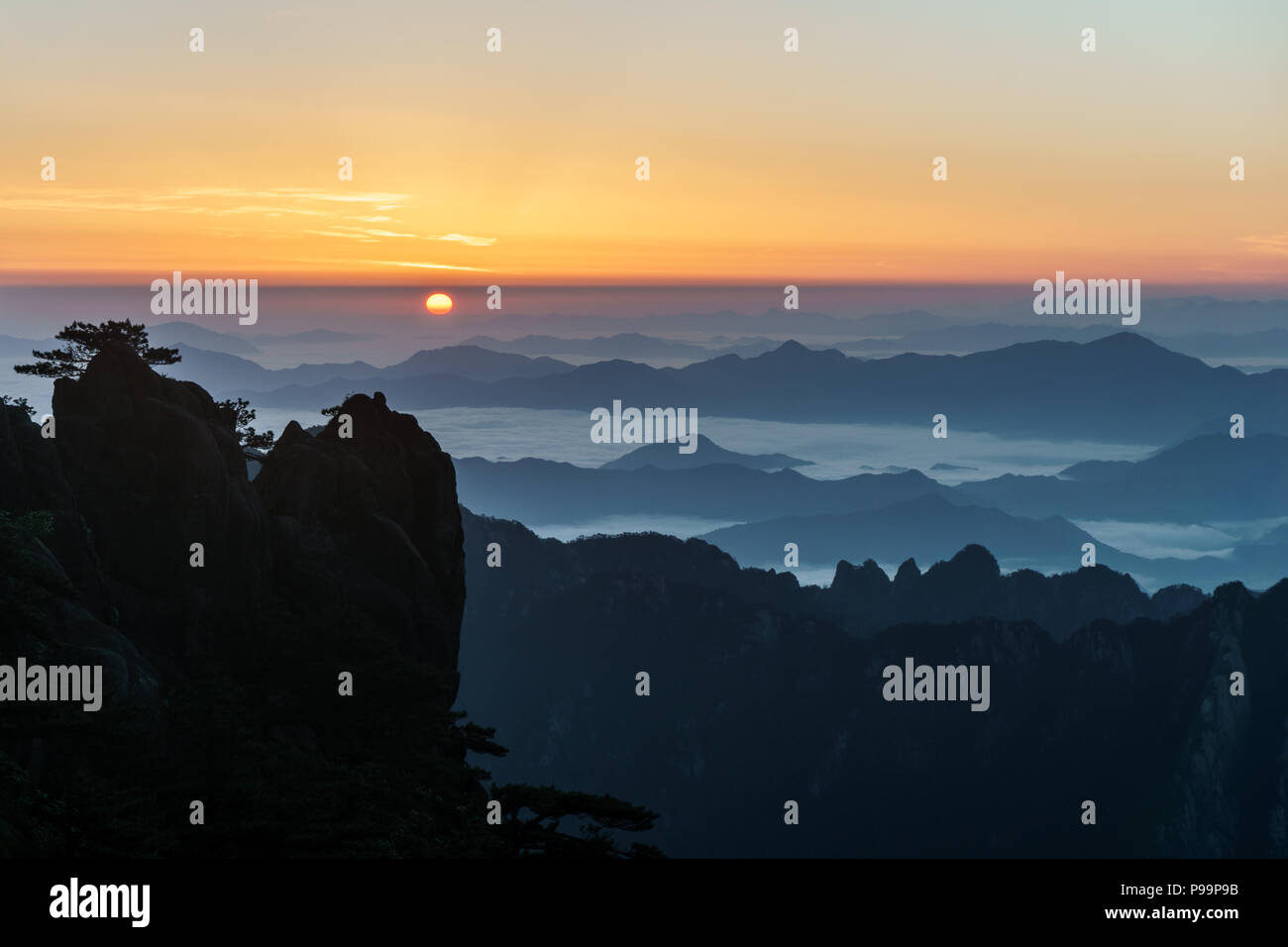 Lever de soleil de l'est le smog au-dessus de la mer de nuages dans les montagnes Huangshan dans le sud de la province de l'Anhui en Chine orientale. Banque D'Images