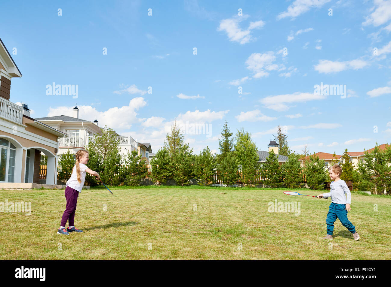 Les enfants jouer au badminton dans la cour avant Banque D'Images