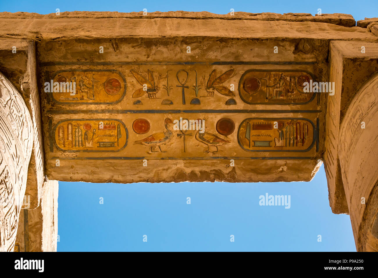 Regardant les hiéroglyphes égyptiens peints colorés en haut de colonnes, salle hypostyle cité parlementaire d'Amon Ra, Temple de Karnak. Louxor, Egypte, Afrique du Sud Banque D'Images