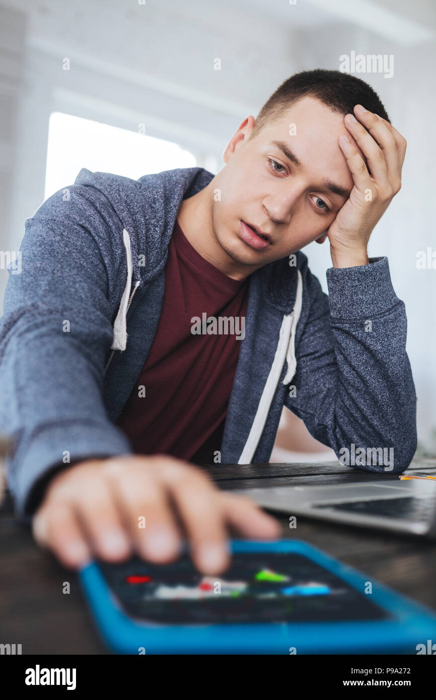 Préoccupé l'homme assis à la table Banque D'Images