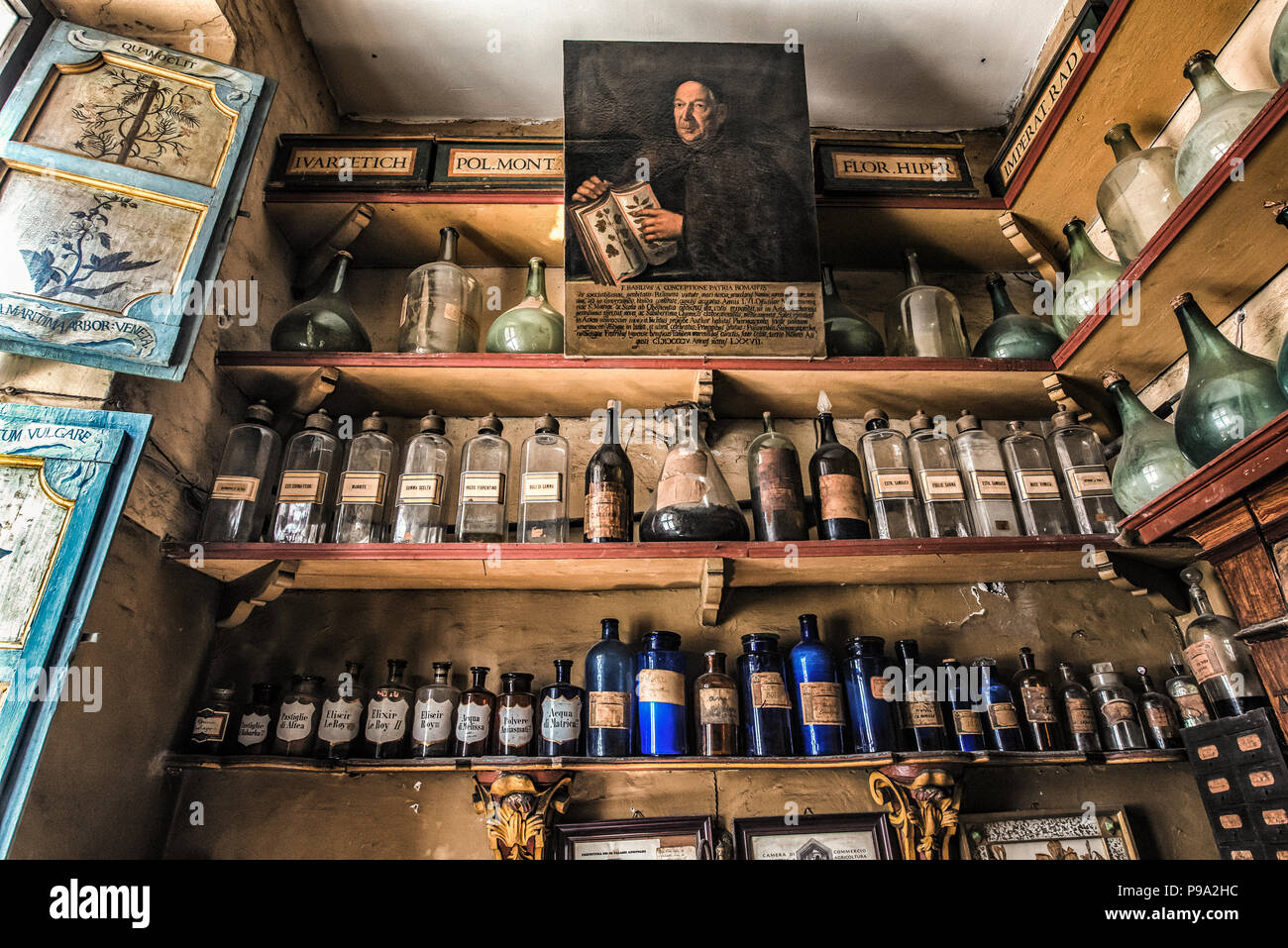 Maintien des étagères de bouteilles de liqueurs médicinales dans la pièce arrière de la salle principale de l'ancienne pharmacie apothicaire et 'Farmacia di S. Maria della Scala" sur la Piazza della Scala in Trastevere trimestre, Rome, Italie Banque D'Images