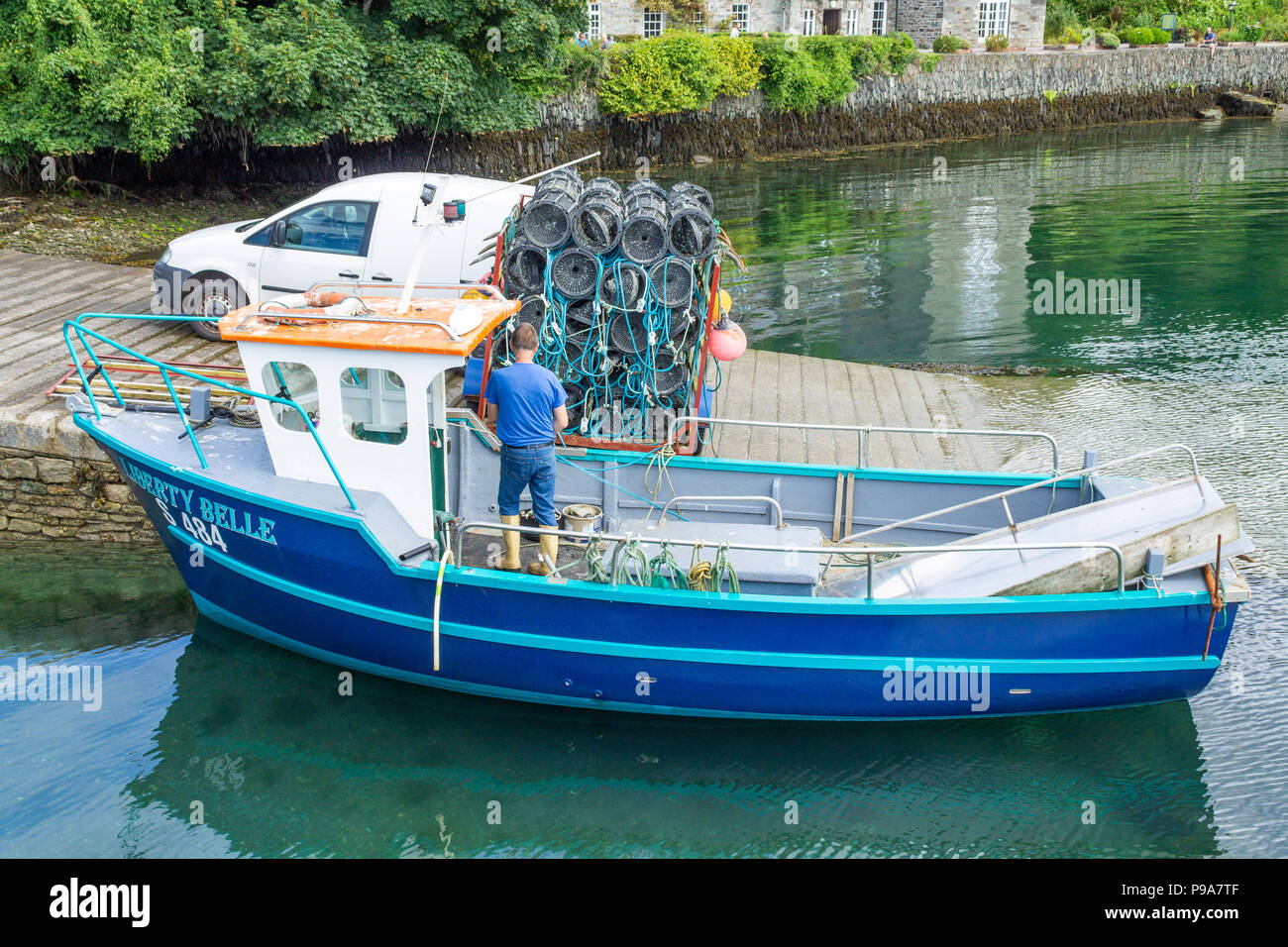 Pêcheur de crevettes chargement des pots ou des pièges à crevettes sur son bateau de pêche. Banque D'Images