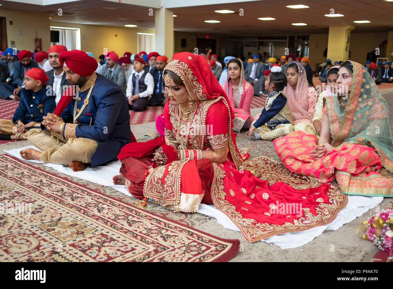 Les mariés à la modifier à leur cérémonie de mariage dans le temple à la Sikh Society à Richmond Hill, Queens, New York. Banque D'Images