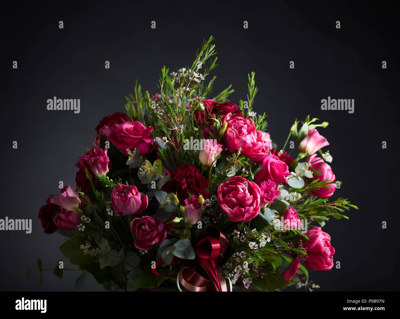 Close up of colorful fleurs de printemps bouquet avec des roses rouges et pivoines sur fond noir. Banque D'Images