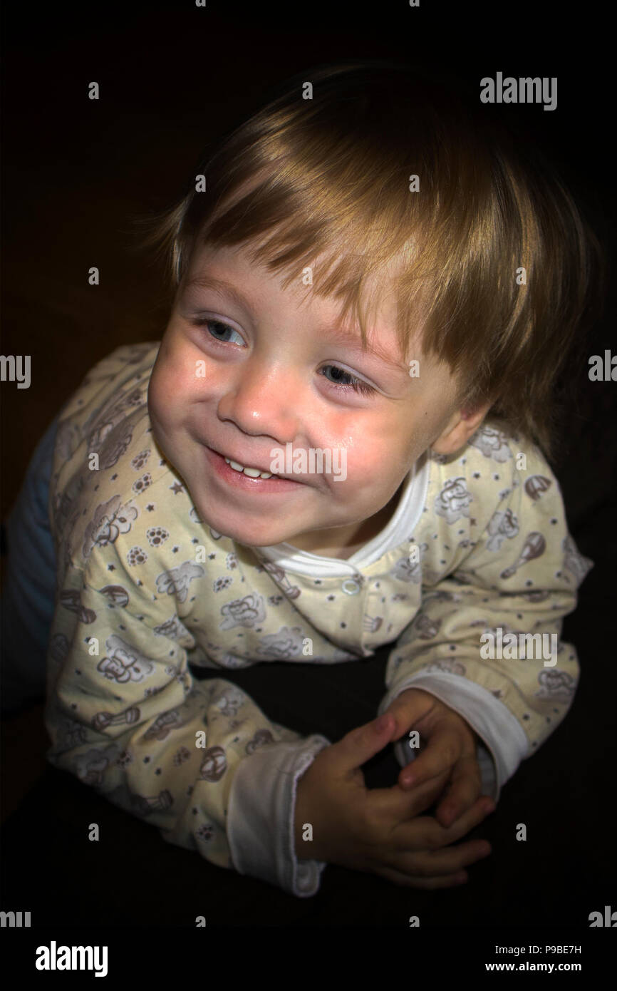 Peu cute smiling blonde boy posing in front of camera, portrait expressif Banque D'Images
