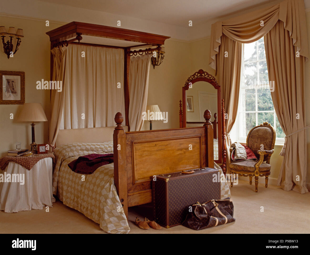 Couvre-lit et rideaux crème sur un lit à dais vintage dans un pays avec des rideaux crème et mobilier assurance Banque D'Images