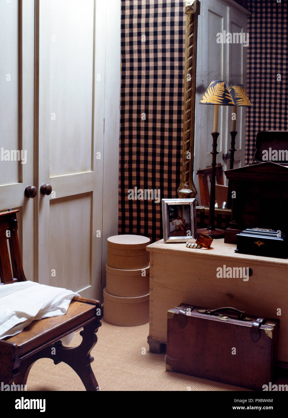 Ancienne valise en cuir et poitrine de pin dans une chambre masculine Banque D'Images