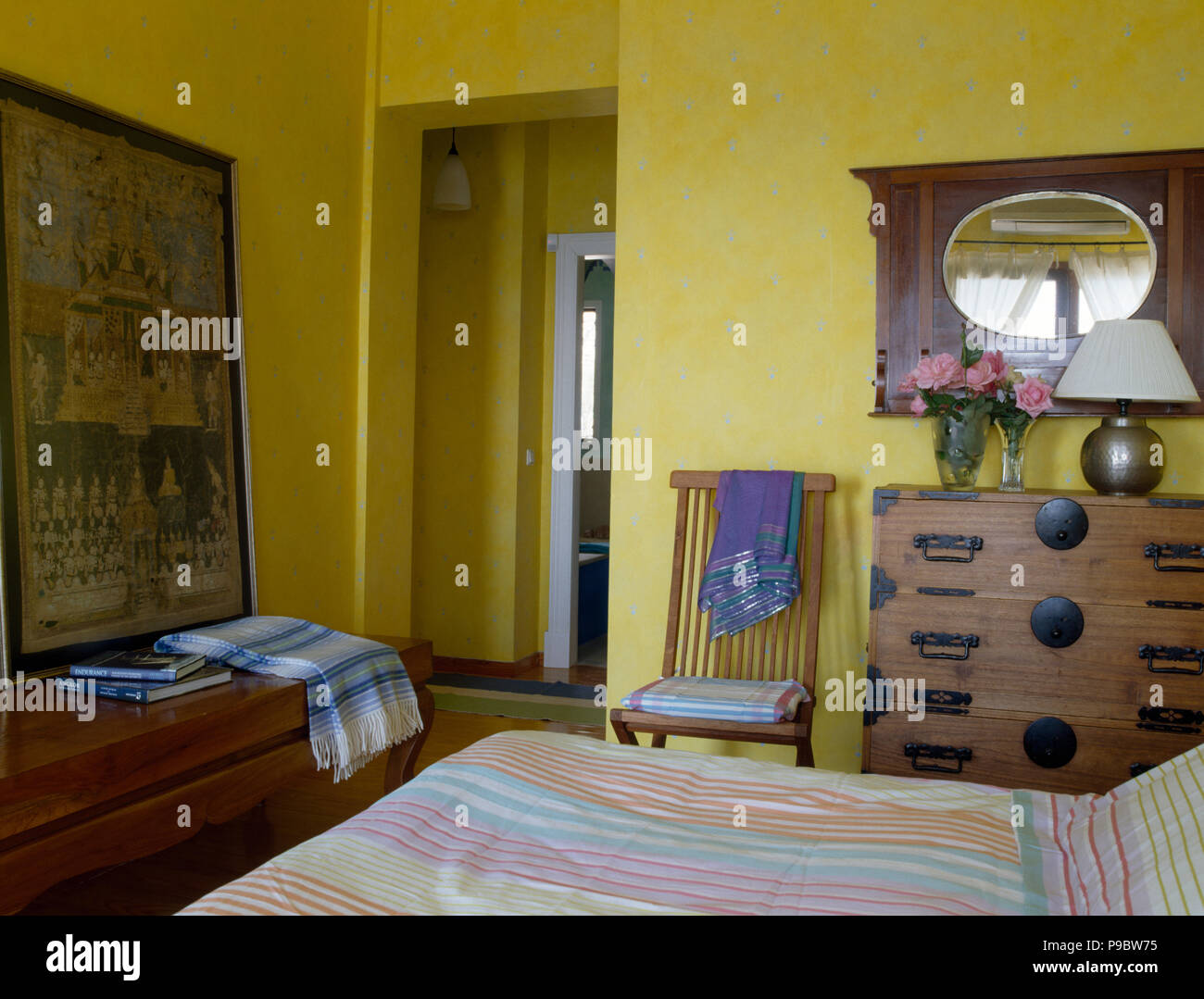 Vintage miroir sur le mur au-dessus de la commode un oriental dans une chambre à coucher côtières jaune Banque D'Images