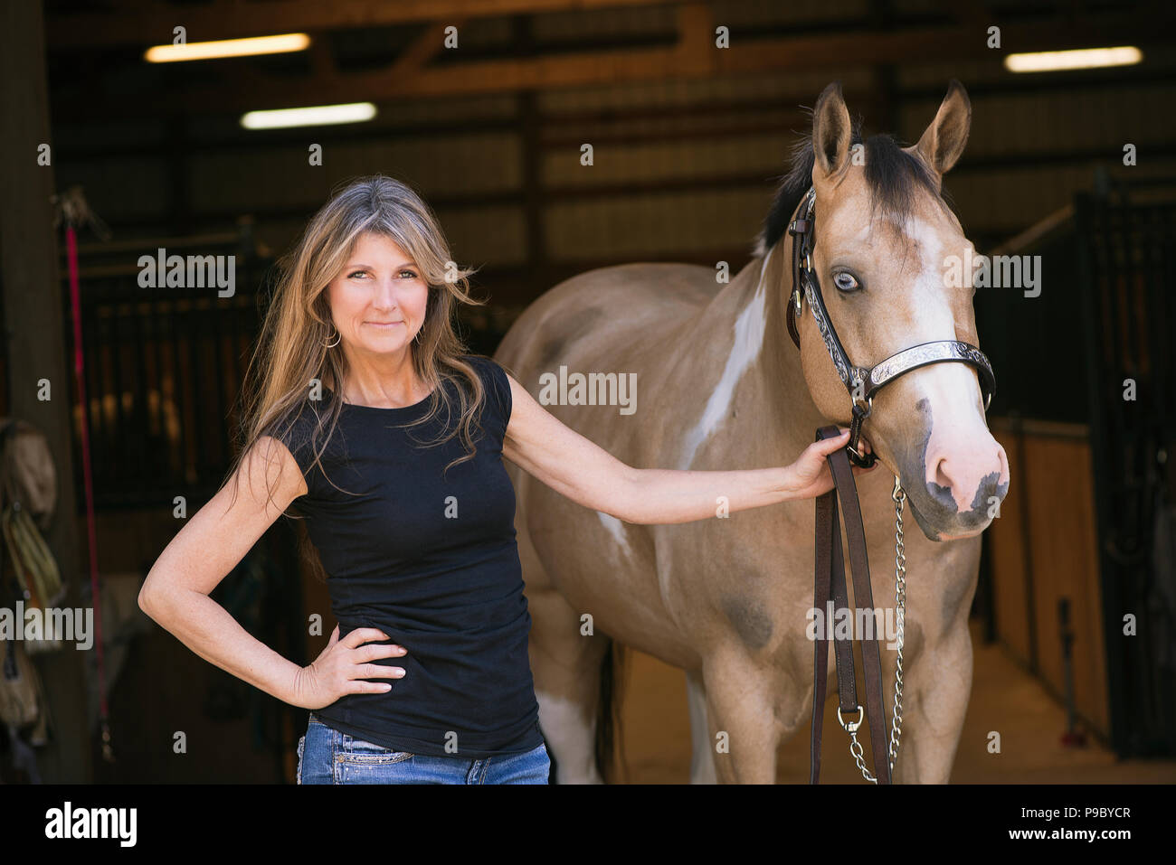 Une femme et son cheval à un stable. Banque D'Images
