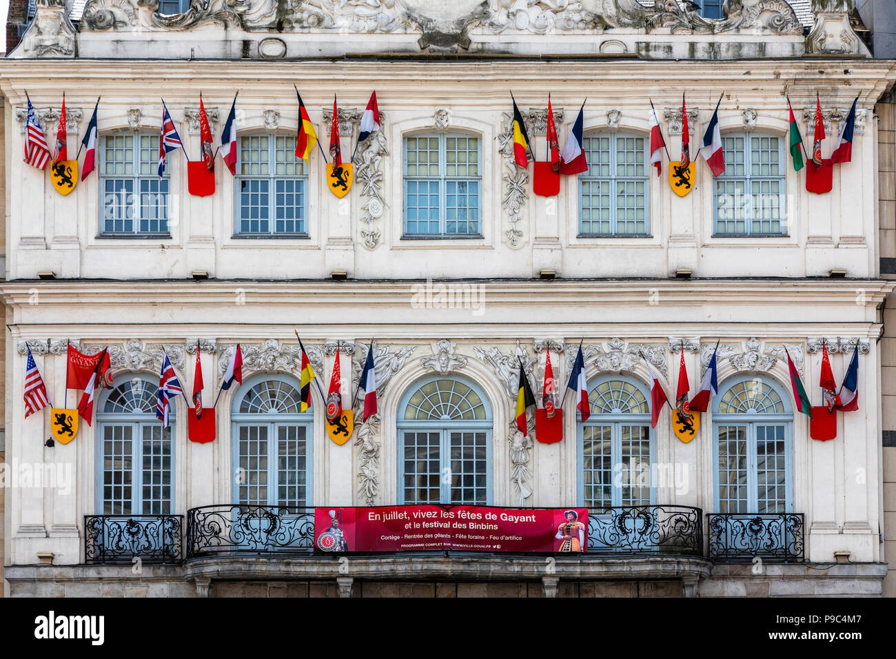 L'extérieur de la fonction publique bureau de tourisme, Douai, Nord, Picardie, France, décoré de drapeaux nationaux et locaux Banque D'Images