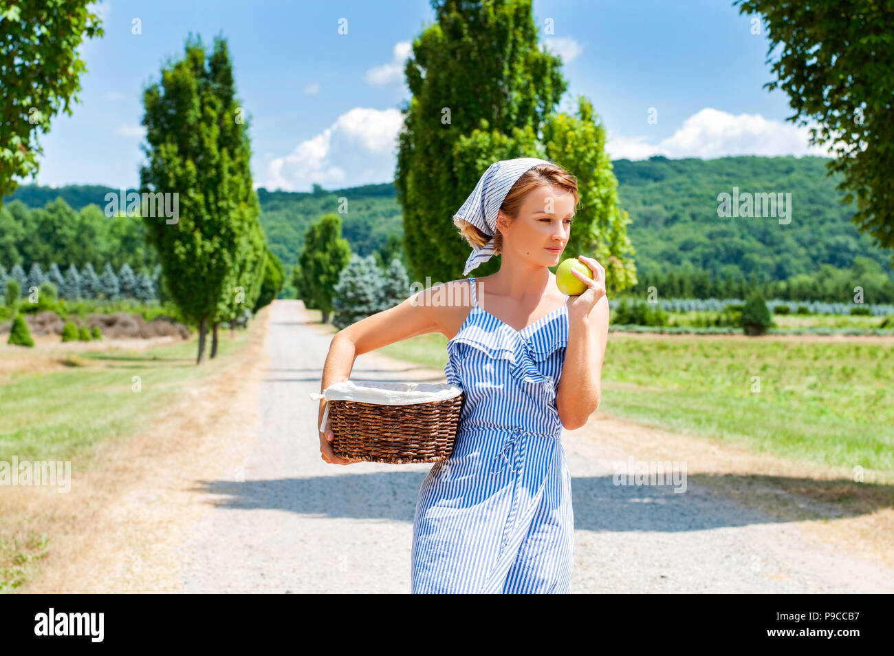 Belle femme en robe avec panier en osier est de marcher le chemin dans la  campagne Photo Stock - Alamy
