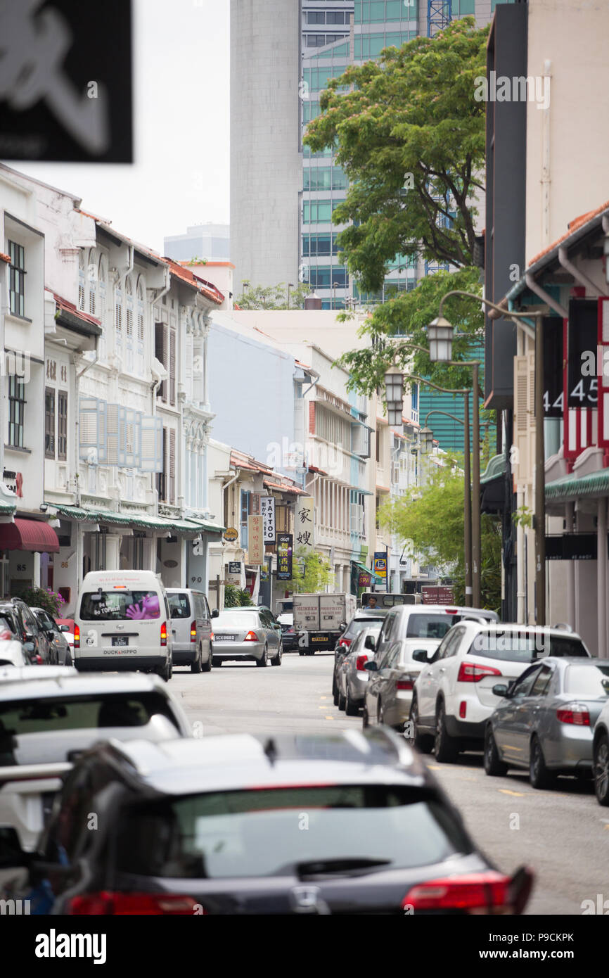 Scène verticale des magasins et des véhicules sur le côté de la route à sens unique. Singapour Banque D'Images
