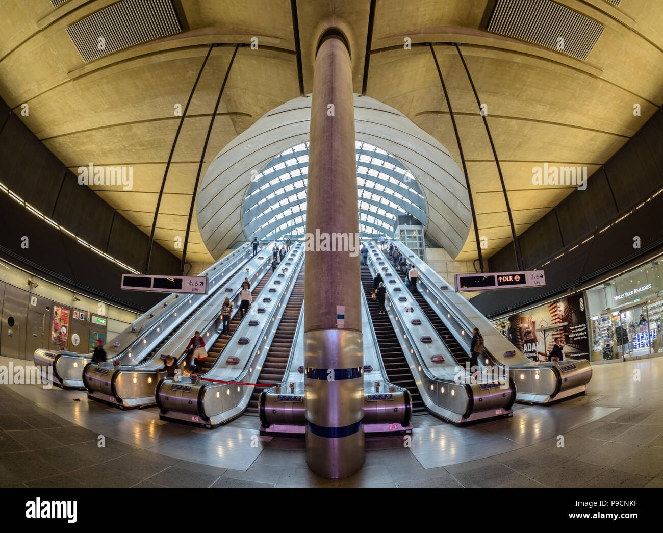 Vue grand angle des navetteurs voyageant le long des escaliers mécaniques à la station de métro de Canary Wharf à Londres Banque D'Images