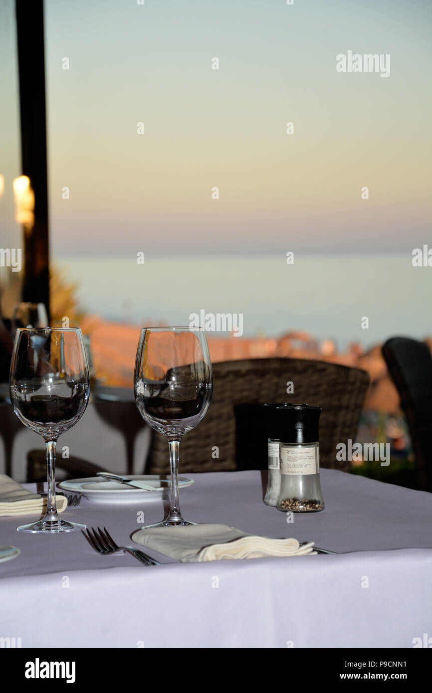 Coucher de soleil sur la mer avec set de table pour le dîner et des verres à vin Banque D'Images