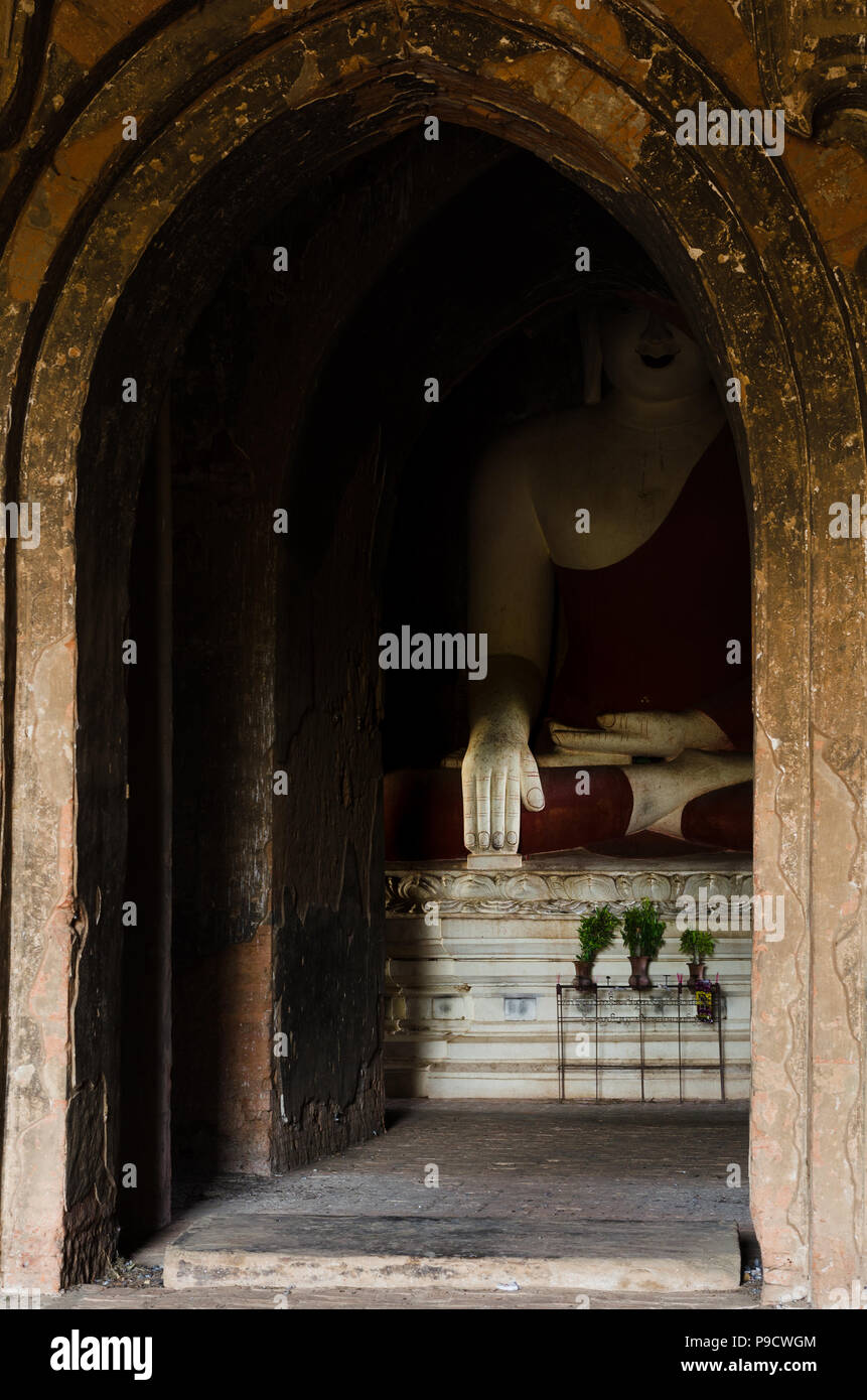 Une plus grande que la vie d'une statue de Bouddha assis affiche le geste de toucher la main de la Terre, enfermé dans un lieu de culte à Bagan Temple Valley, le Myanmar. Banque D'Images