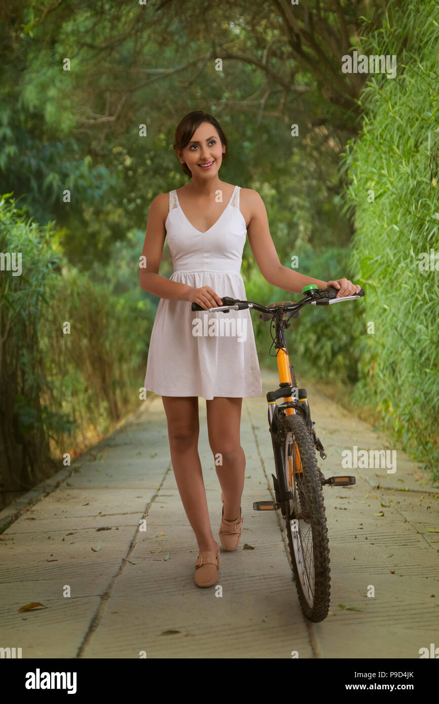 Young woman in park with bicycle Banque D'Images