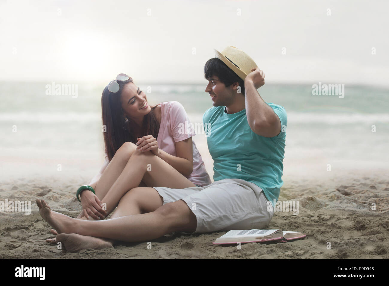 Young couple sitting on beach Banque D'Images