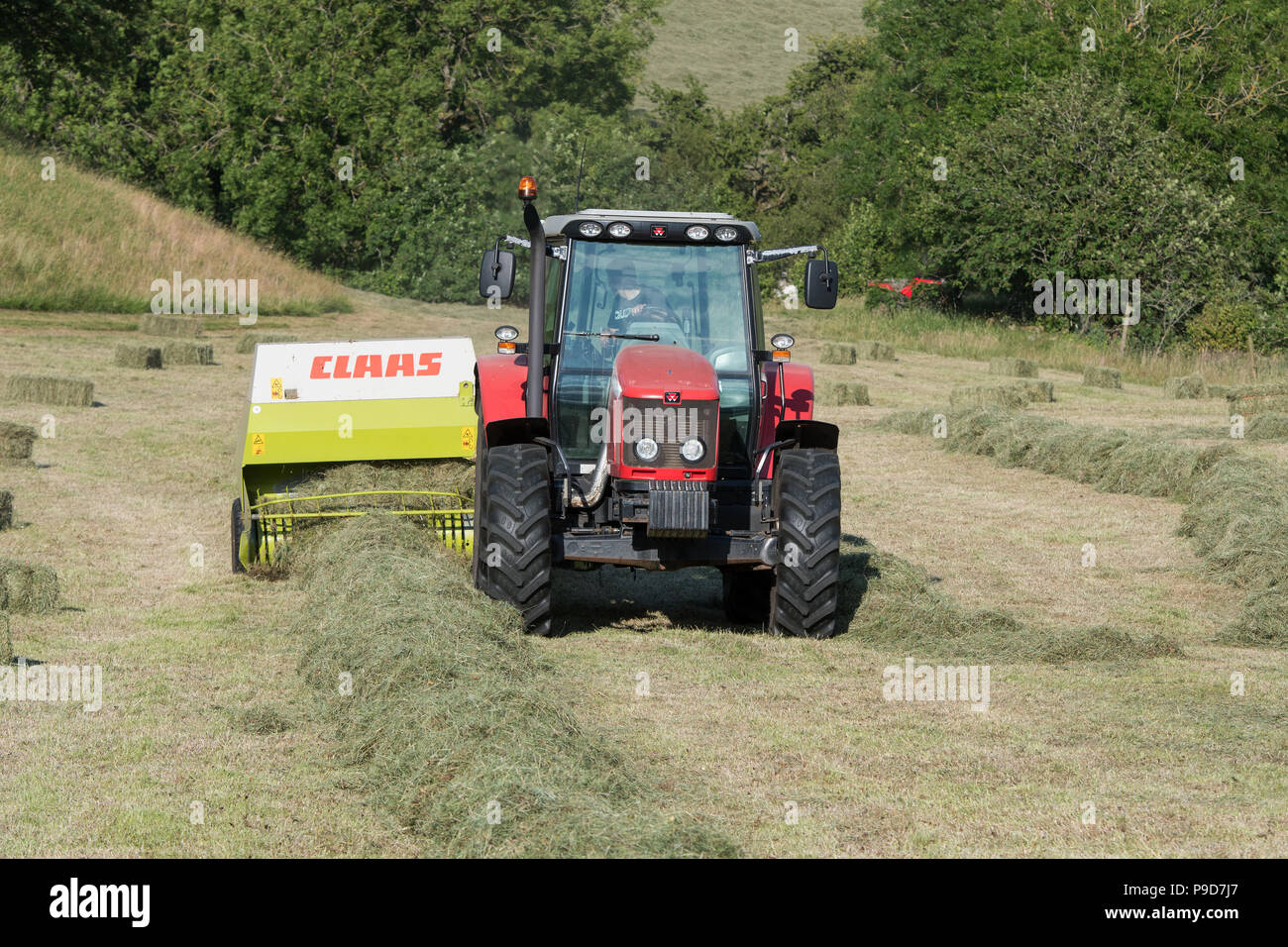 Agriculteur de Swaledale, Yorkshire du Nord La réalisation de balles de foin, à l'aide d'un et un Massey Ferguson 5470 Claas ramasseuse-presse. Banque D'Images