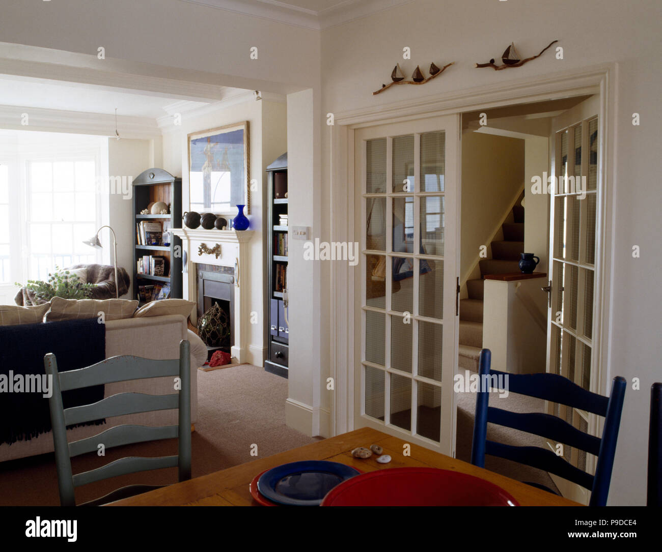 Chaises peintes en bleu clair et double portes dans la salle à manger du salon pays blanc Banque D'Images