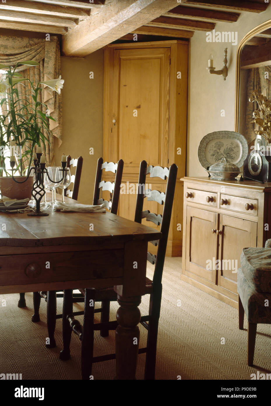 Tapis en sisal en poutres apparentes au cottage salle à manger avec table et chaises ladderback antique Banque D'Images