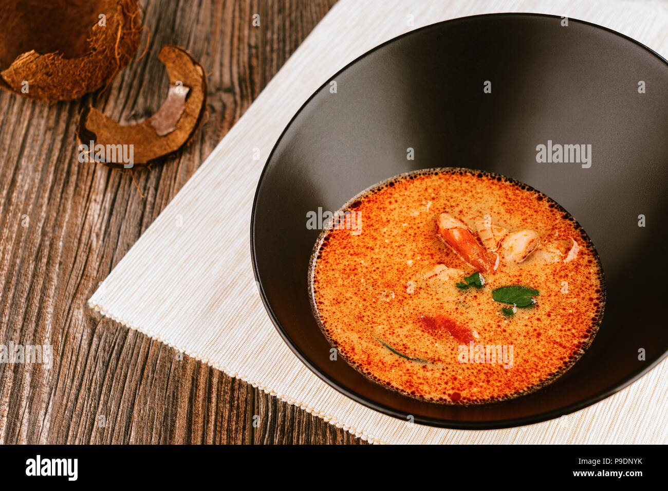 Soupe de fruits de mer asiatique tom yam avec coque de noix de coco Banque D'Images