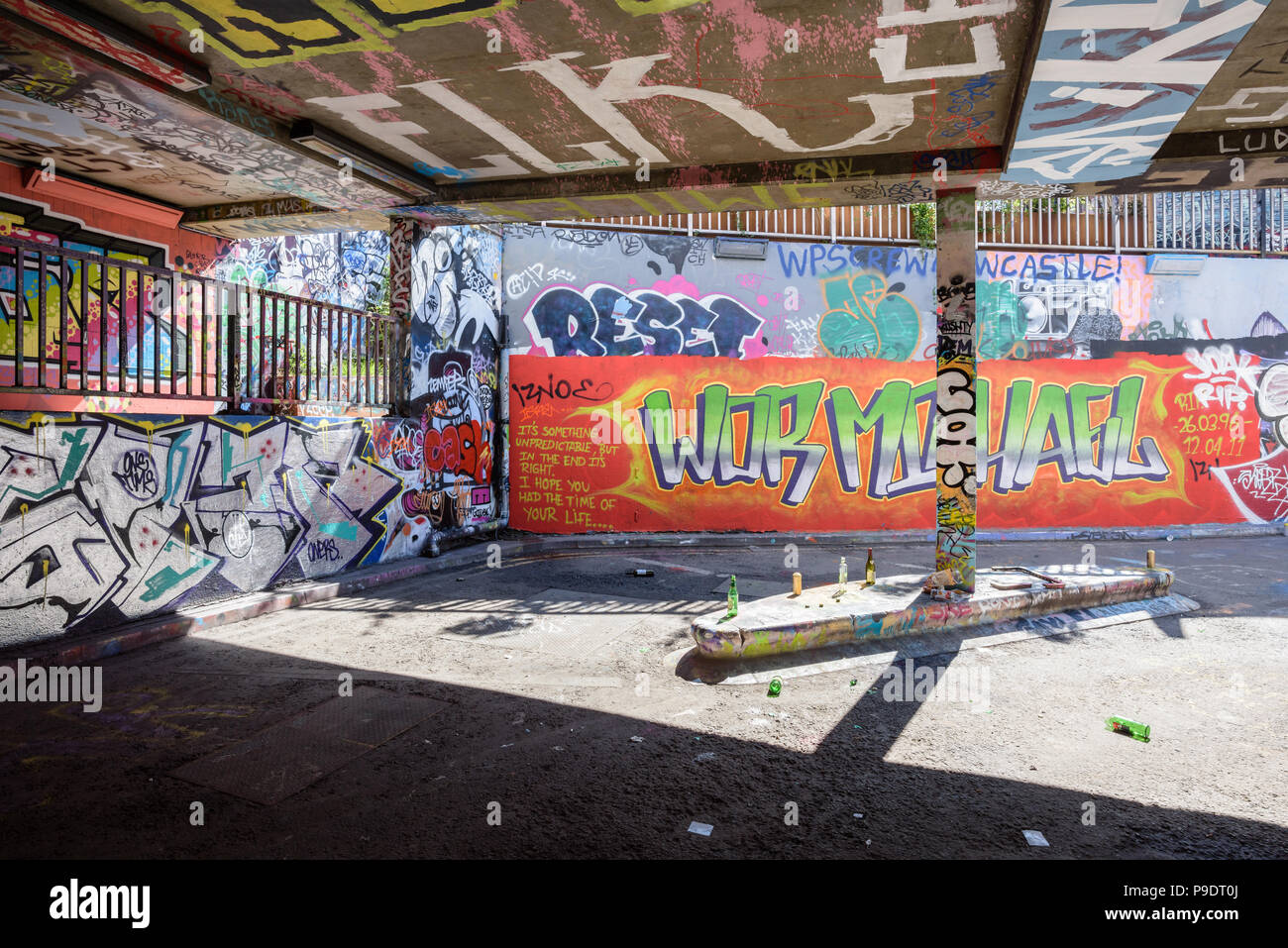 Des bouteilles vides et les canettes d'alcool à gauche dans Tunnel Banksy Leake Street à Waterloo, Londres, sur une toile de graffitis sur les murs Banque D'Images
