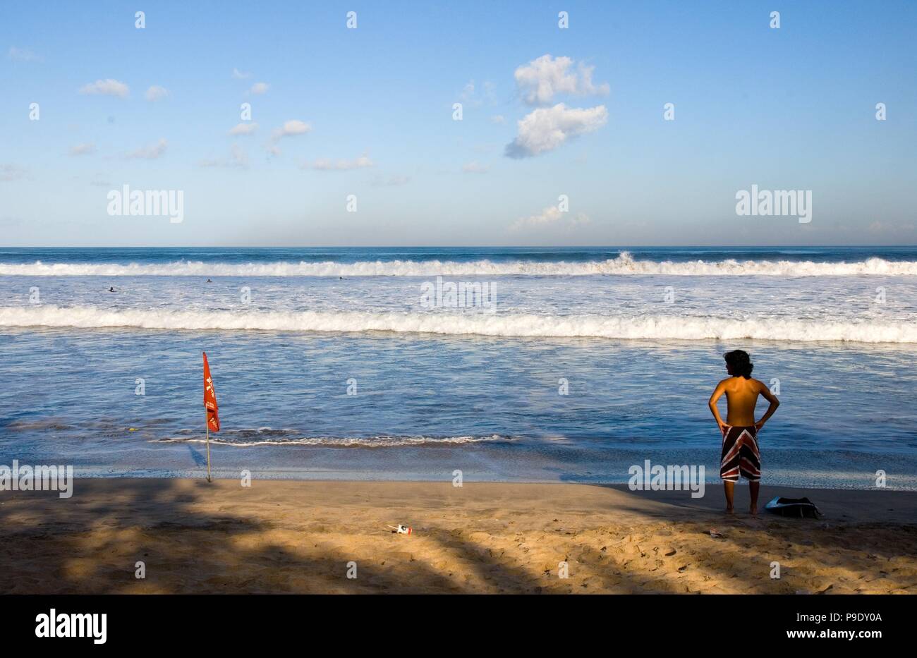 Un internaute est à la recherche à la mer pour vérifier les vagues. Lieu : plage de Kuta, à Bali, en Indonésie. Banque D'Images