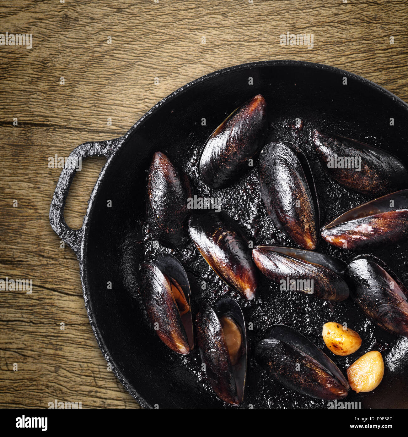 Poêle avec moules cuites sur fond de bois Banque D'Images