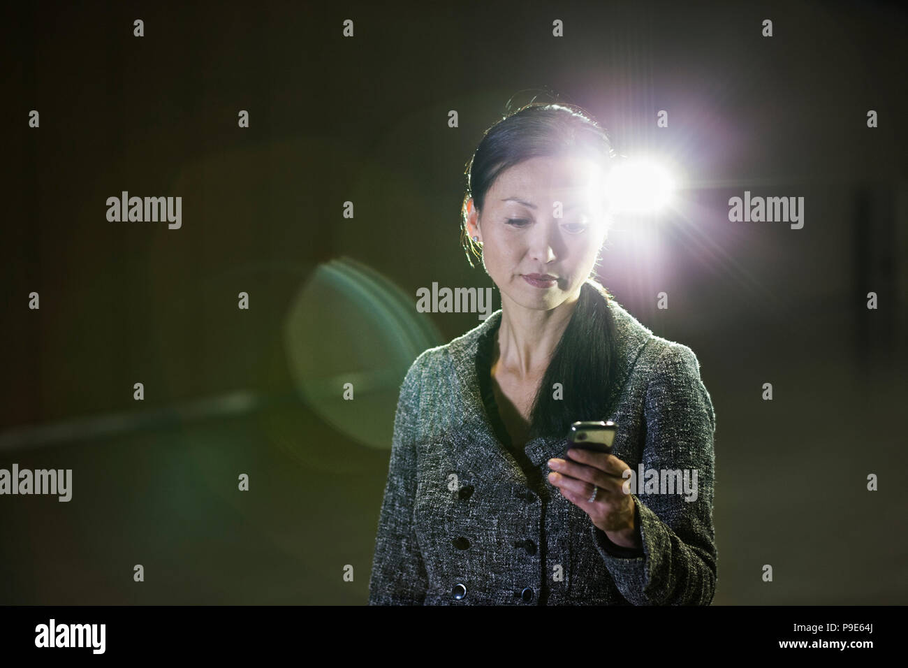 Une asiatique businesswoman dans un spot travaillant avec son téléphone cellulaire. Banque D'Images