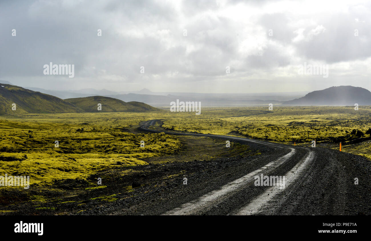 Paysage de lave d'Islande, de la route et les montagnes lointaines Banque D'Images