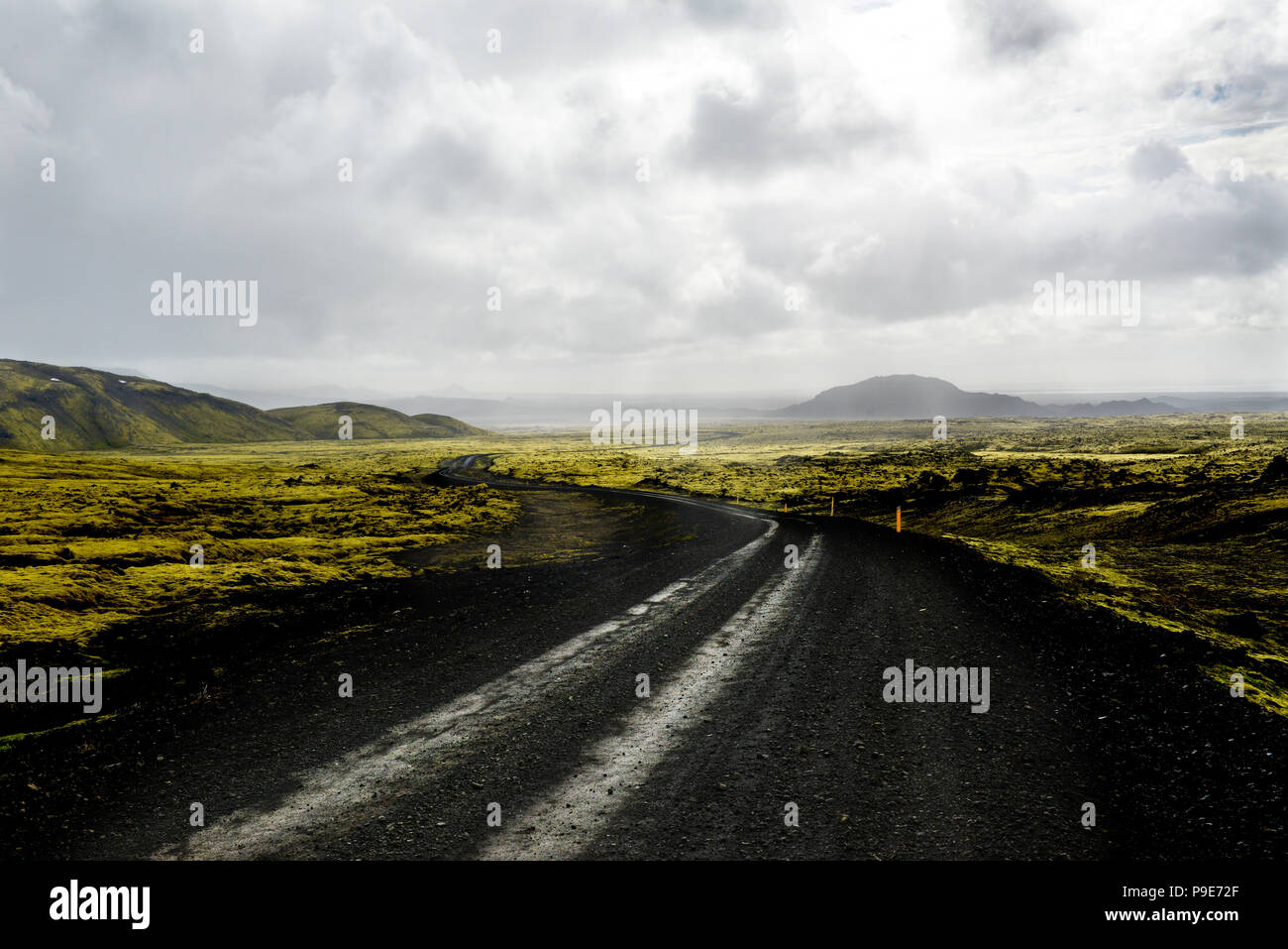 Paysage de lave d'Islande, de la route et les montagnes lointaines Banque D'Images
