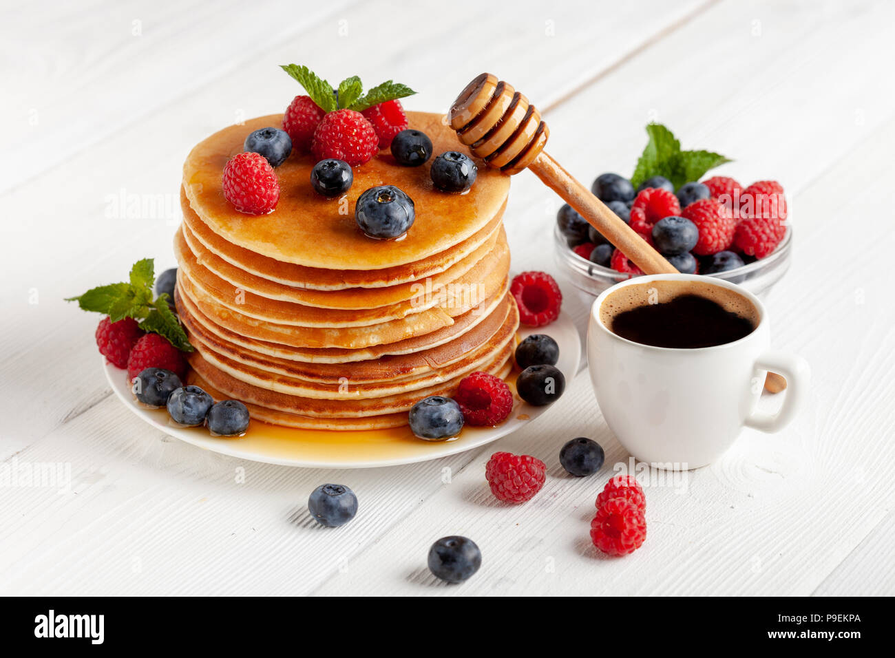 American Blueberry et de framboise crêpes avec du café sur la table en bois blanc Banque D'Images