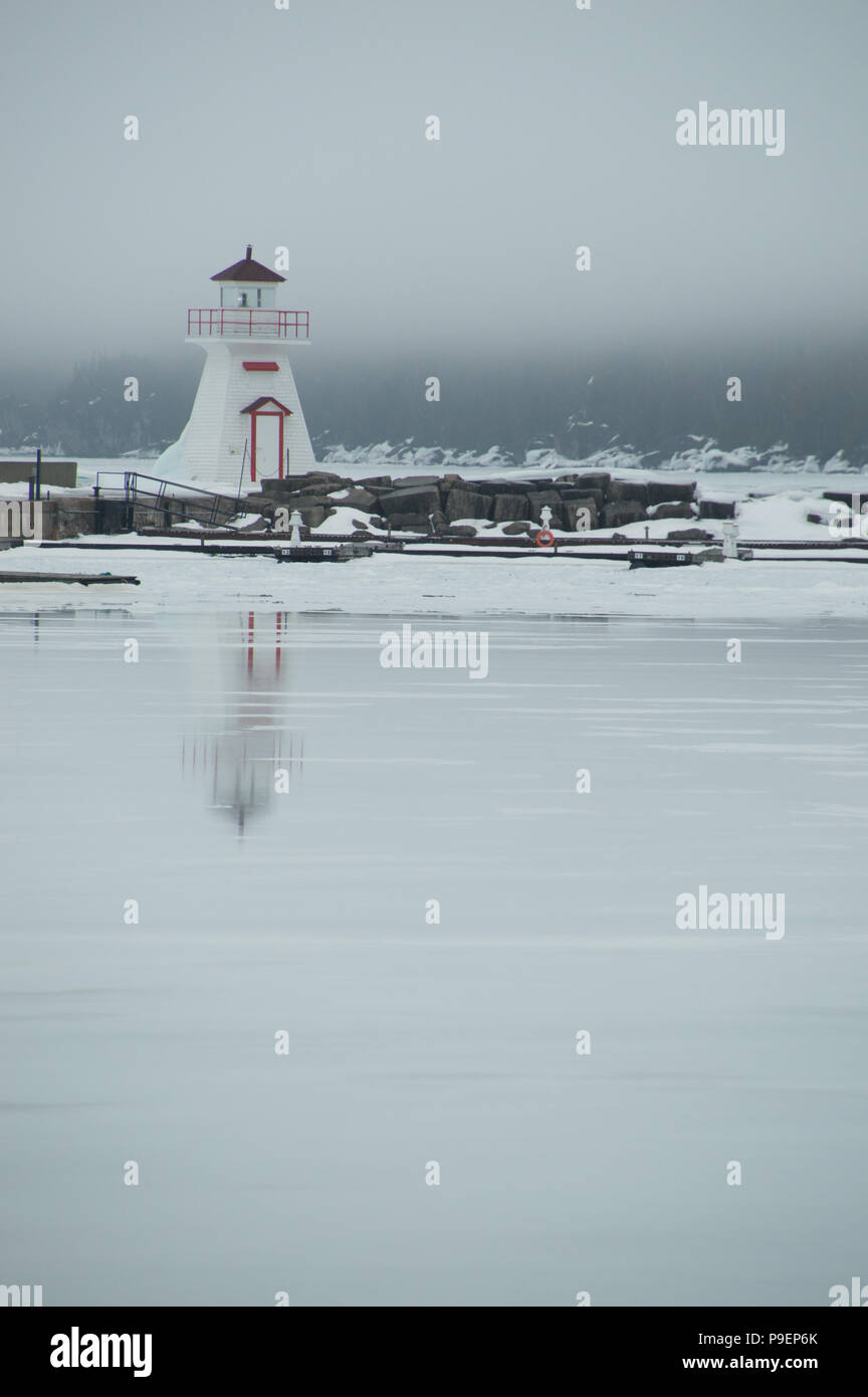 Lion's Head Harbour (Péninsule de Bruce, en Ontario) avec la fonte de la glace sur la baie reflétant et humide. Banque D'Images