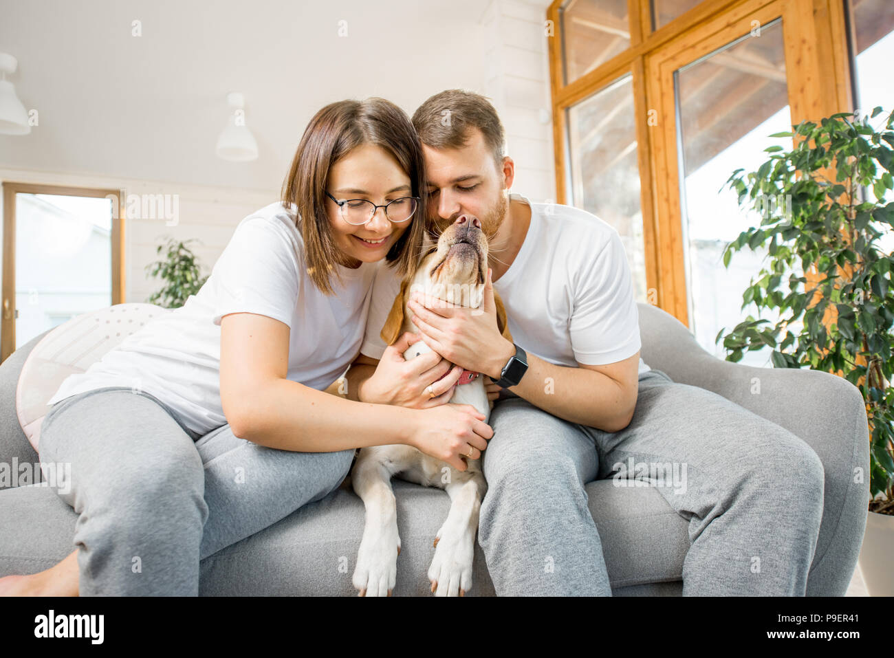 Couple avec chien sur le canapé à la maison Banque D'Images