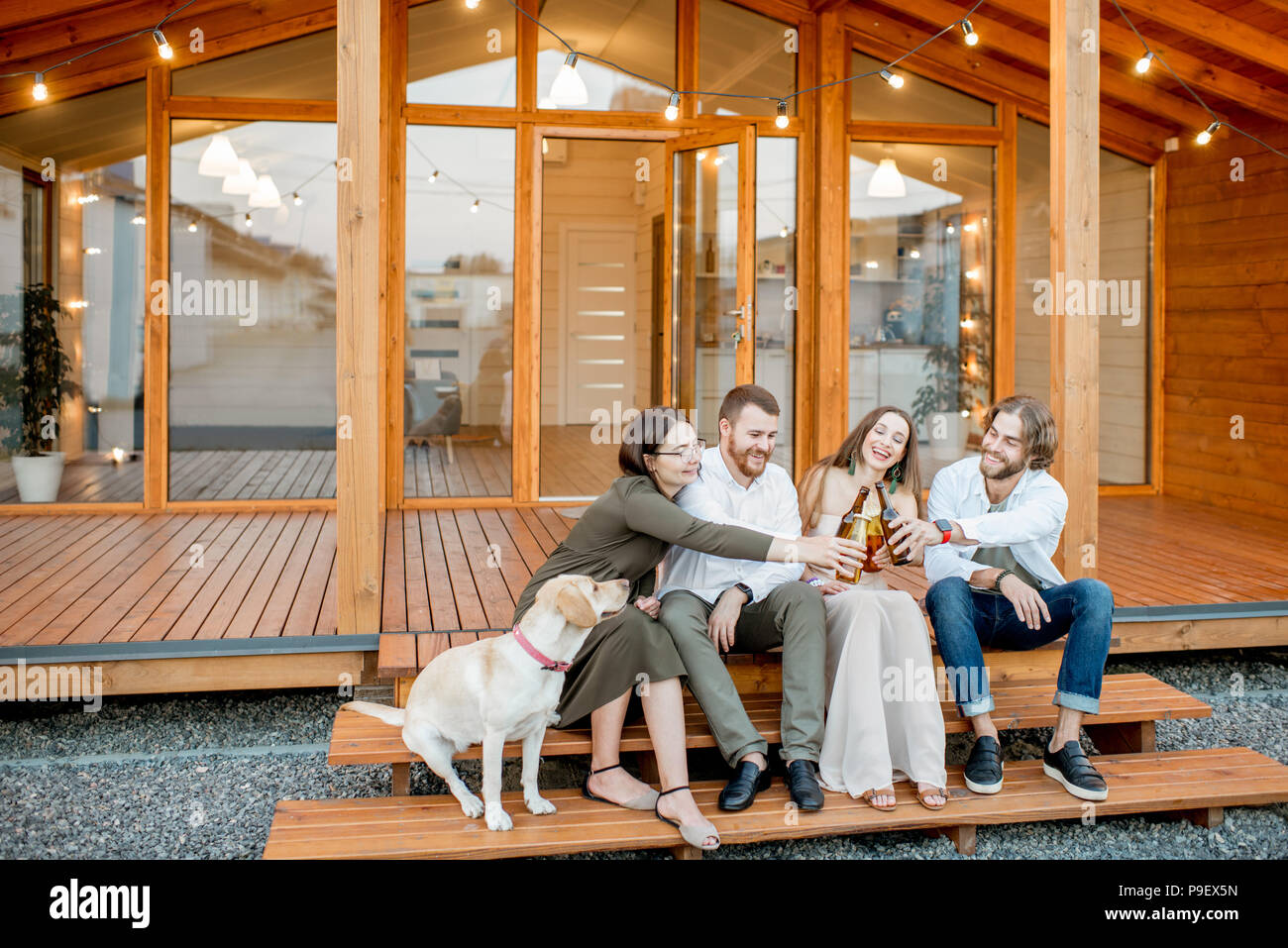 Les amis avec le chien en face de la maison Banque D'Images