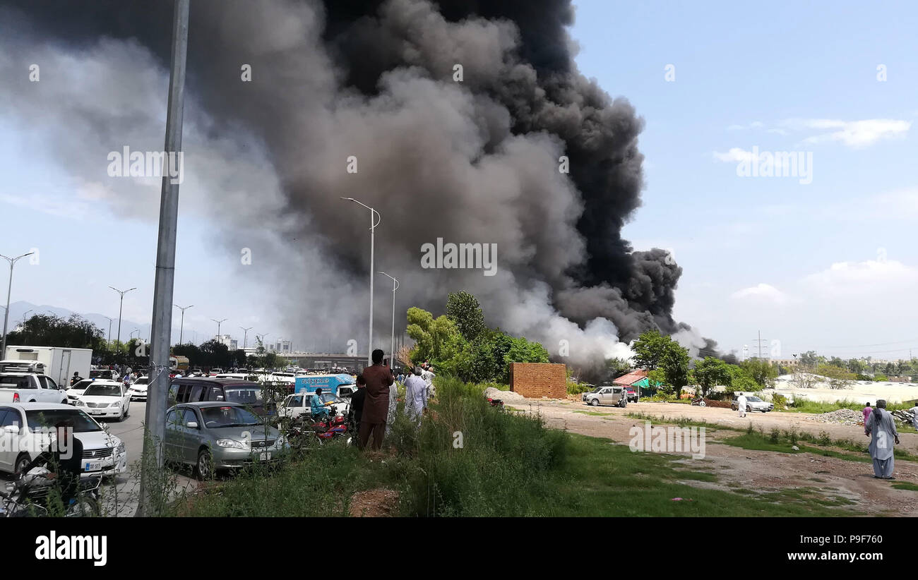 Islamabad, Pakistan. 18 juillet, 2018. Photo prise par le téléphone portable présente un énorme nuage de fumée noire à Islamabad, capitale du Pakistan, le 18 juillet 2018. Au moins 150 magasins ont été détruit dans un incendie de haute intensité qui a éclaté dans un marché hebdomadaire de la capitale pakistanaise d'Islamabad le mercredi, des fonctionnaires et des rapports locaux dit. Credit : Jamil Bhatti/Xinhua/Alamy Live News Banque D'Images