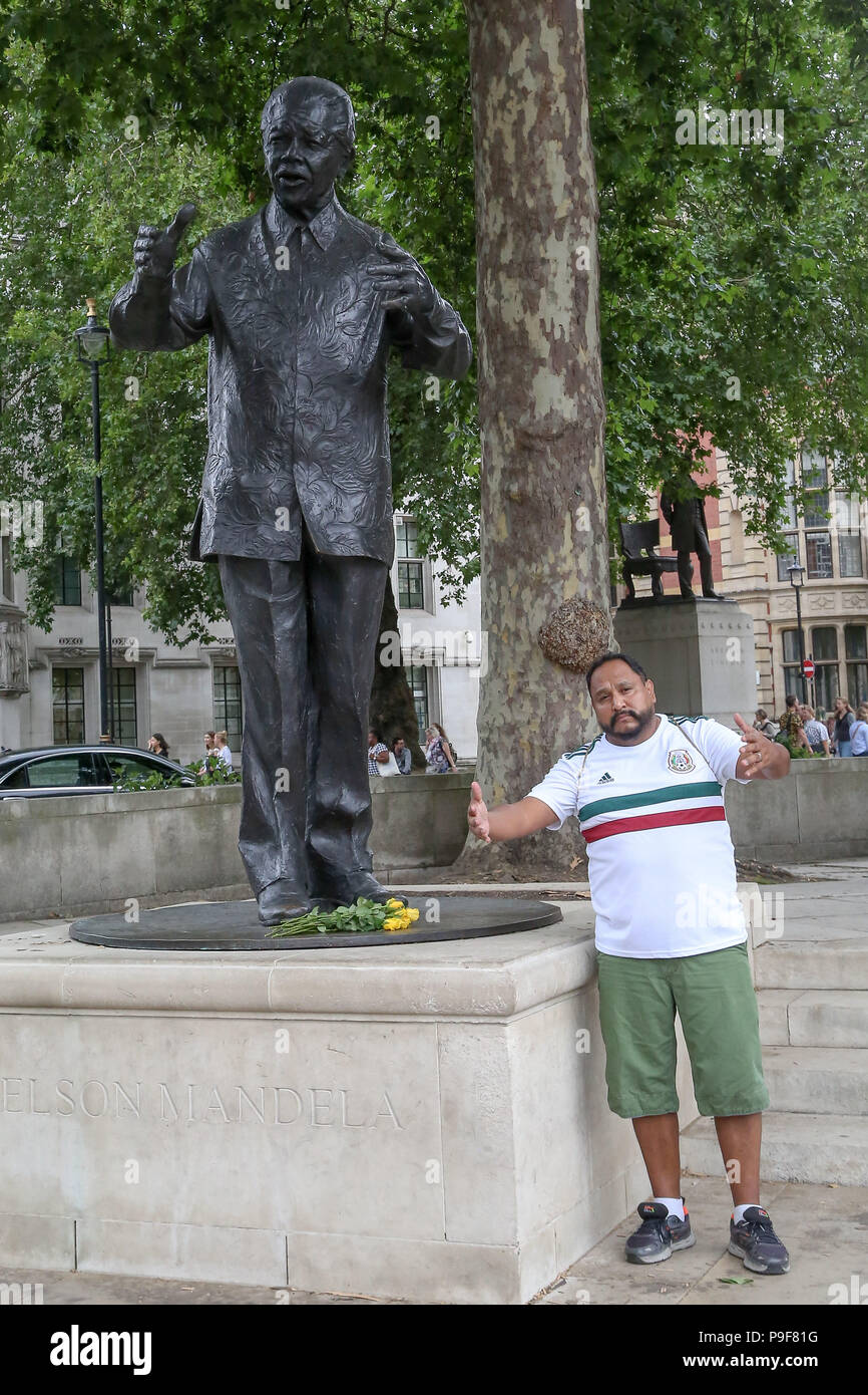 La place du Parlement, Westminster. Londres. UK 18 Juillet 2018 - Un homme pose pour les photographies avec Nelson MandelaÕs statue en place du Parlement, Westminster, car elle marque le centenaire de la naissance de Nelson Mandela qui a mené la lutte contre le régime de l'apartheid en Afrique du Sud. Credit : Dinendra Haria/Alamy Live News Banque D'Images