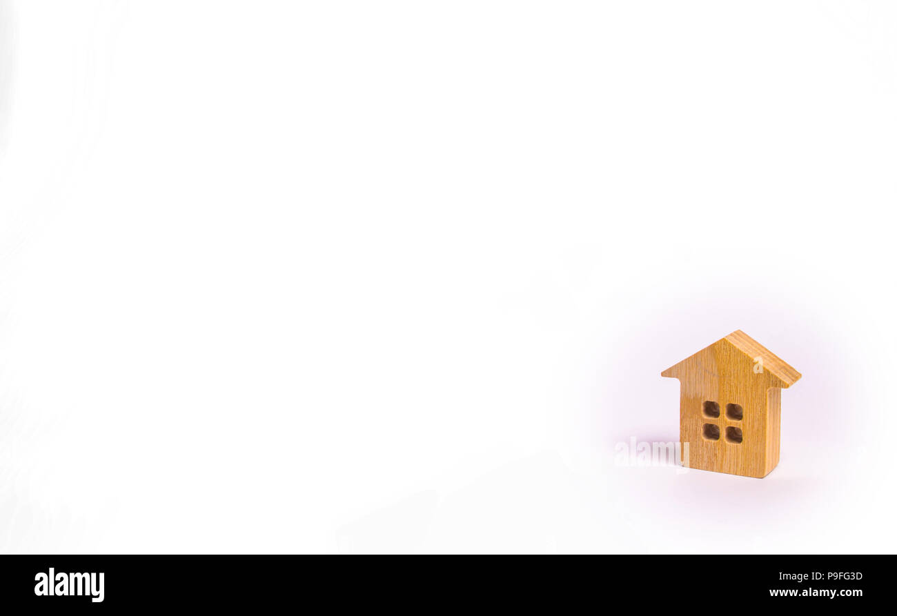 Une petite maison en bois se dresse sur un fond blanc. Le concept de l'achat et la vente de l'immobilier, la location. Recherche d'une chambre. Le logement abordable, la cre Banque D'Images