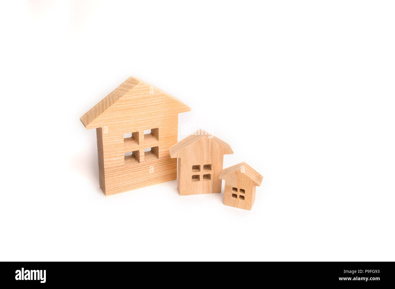 Trois maisons en bois stand dans une rangée dans l'ordre décroissant sur un fond blanc. Le concept de l'achat et la vente de l'immobilier. Quartier résidentiel, de vélos Banque D'Images