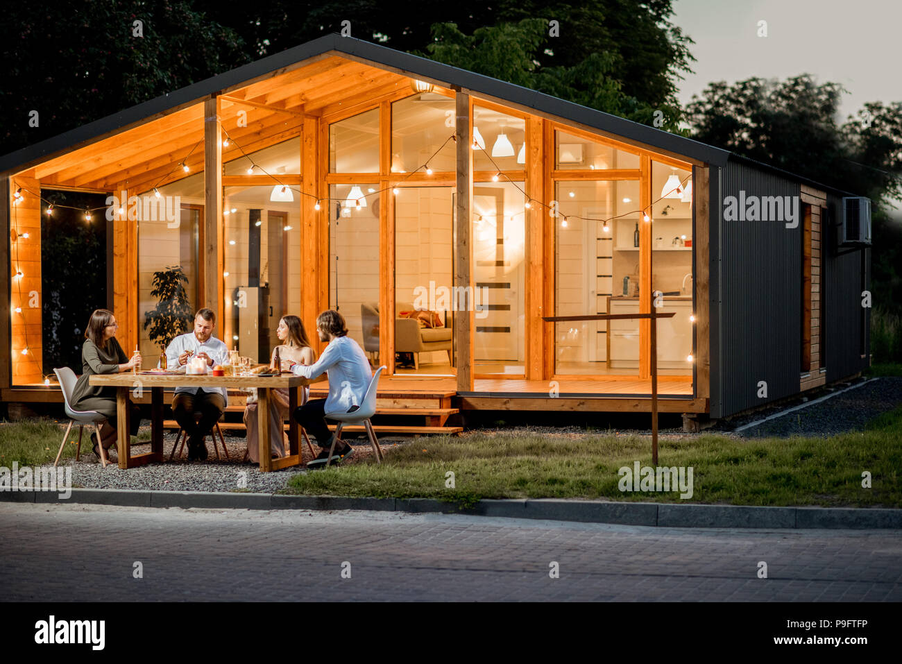 Arrière-cour de la maison avec des gens assis à la table Banque D'Images