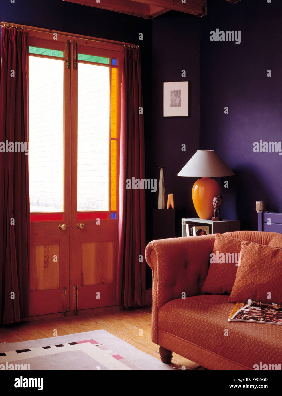 Demi-double portes en violet salon avec canapé orange Banque D'Images