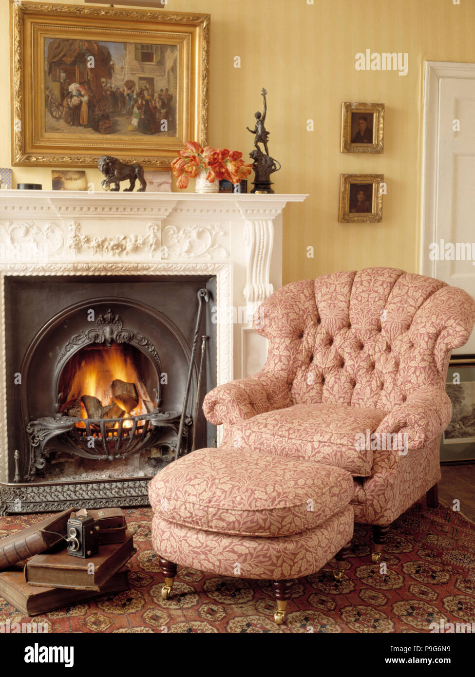 Fauteuil à côté d'une cheminée dans un salon traditionnel Photo Stock -  Alamy