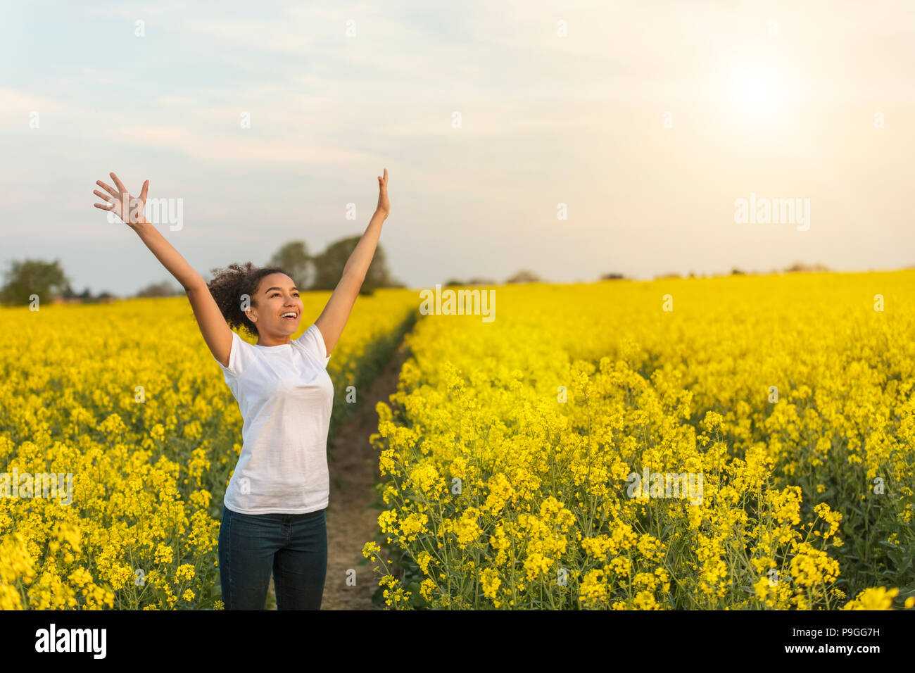 Portrait de plein air en soirée d'or soleil de beau happy mixed race African American girl adolescent femme jeune femme smiling rire arms rais Banque D'Images