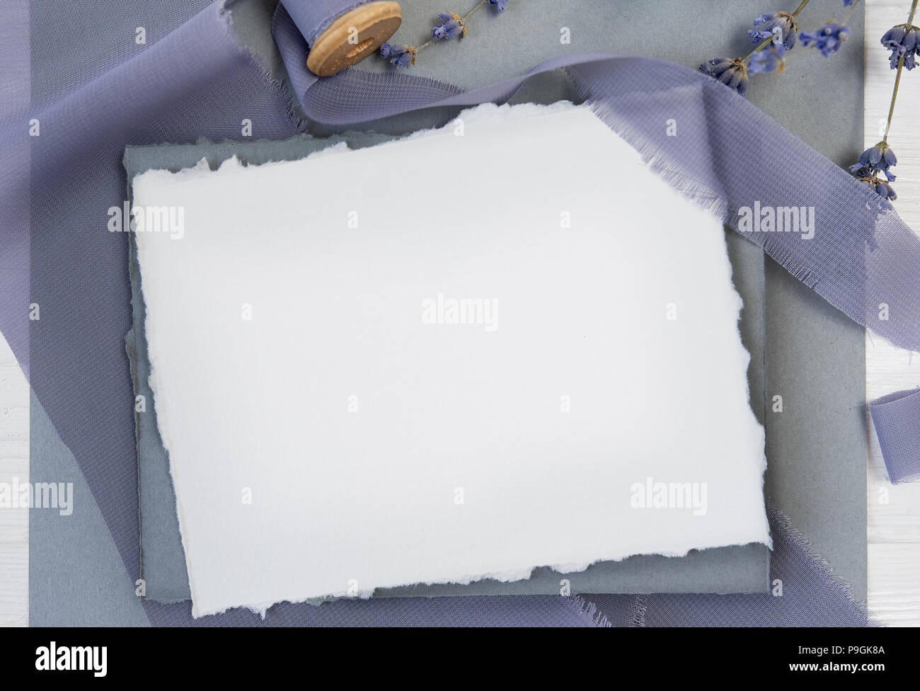 Carte de voeux vierge blanc ruban sur un fond de toile bleue avec des fleurs de lavande sur un fond blanc. Immersive avec enveloppe et carte vierge avec de l'espace pour votre texte. Mise à plat. Vue d'en haut Banque D'Images