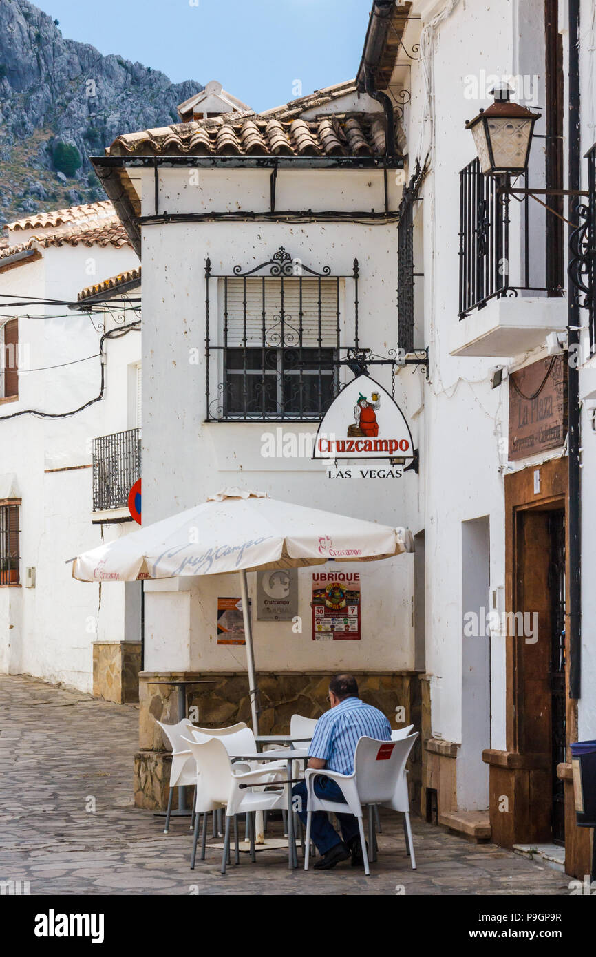 Benaocaz, Espagne - 21 juin 2018 : l'homme est assis à l'extérieur d'un bar avec Cruzcampo signe. Le bar est nommé Las Vegas. Banque D'Images
