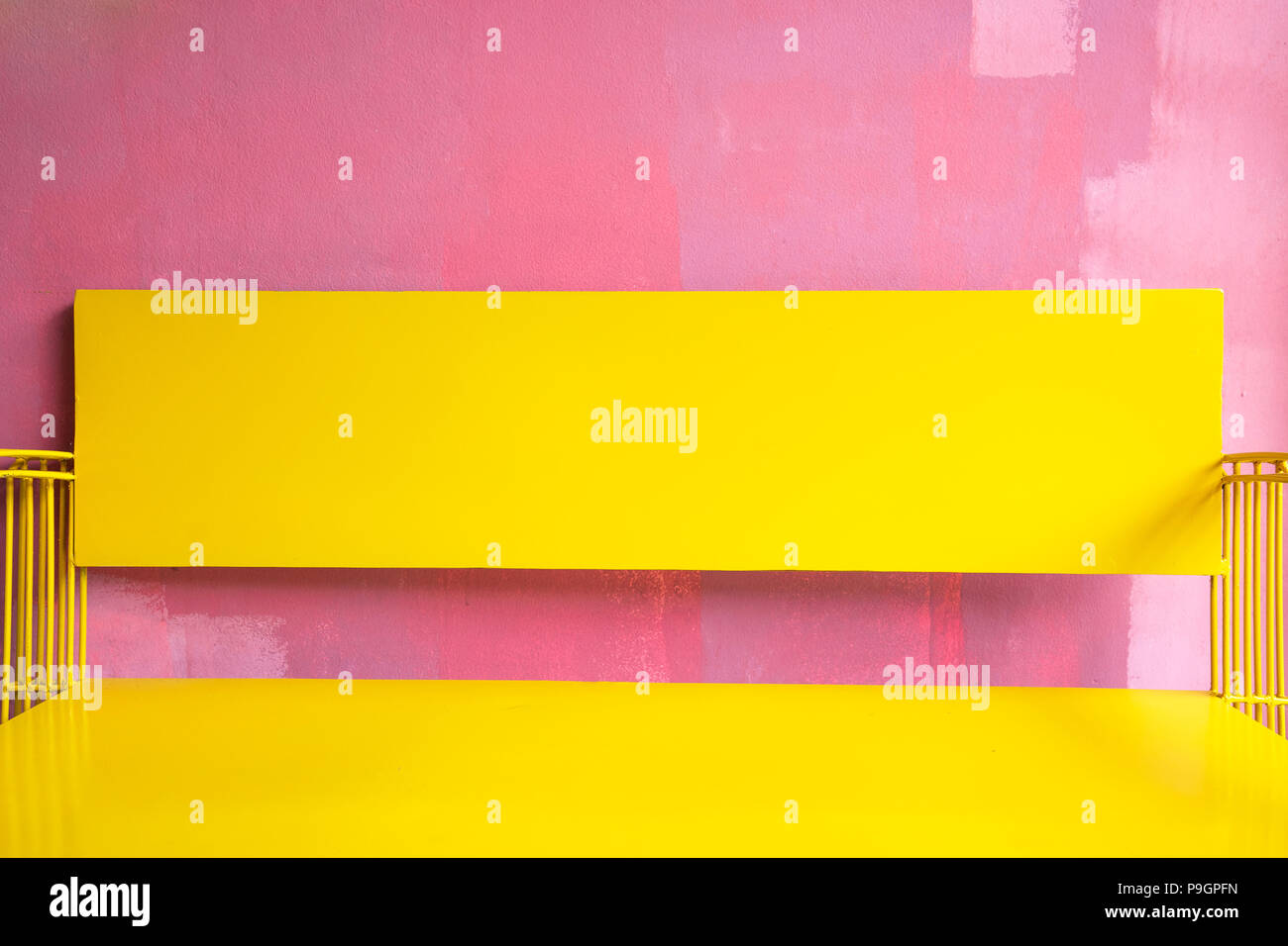 Banc jaune lumineux Vintage grunge contre mur peint rose brillant, couleur d'été Banque D'Images