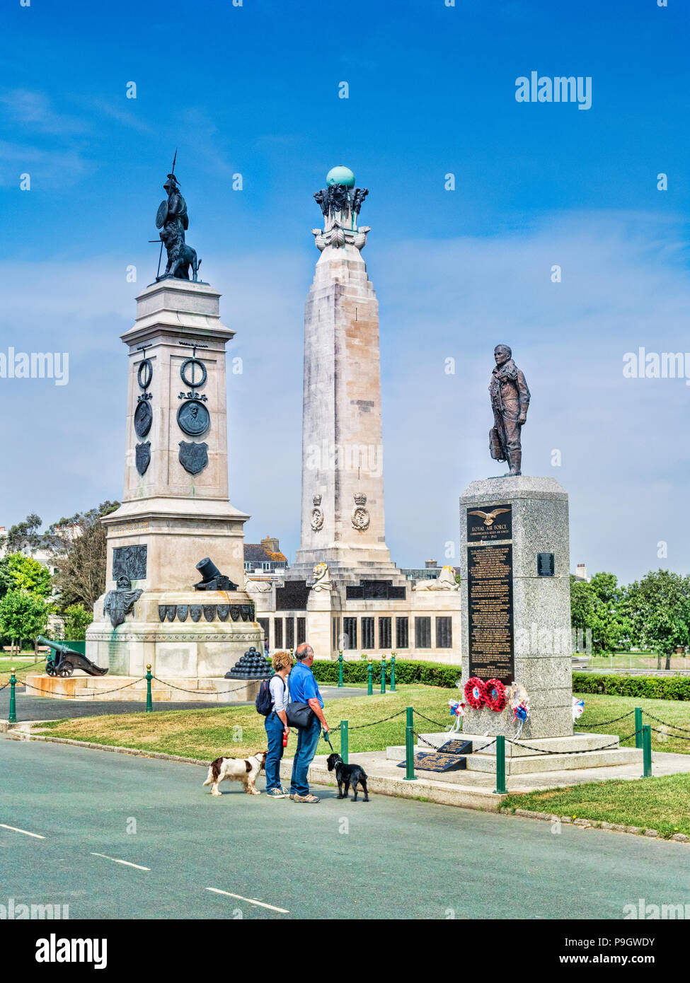 8 juin 2018 : Plymouth, Devon UK - Couple avec deux chiens à la recherche de monuments à Plymouth Hoe - de gauche à droite, l'Armada Monument, la Royal Navy Monum Banque D'Images